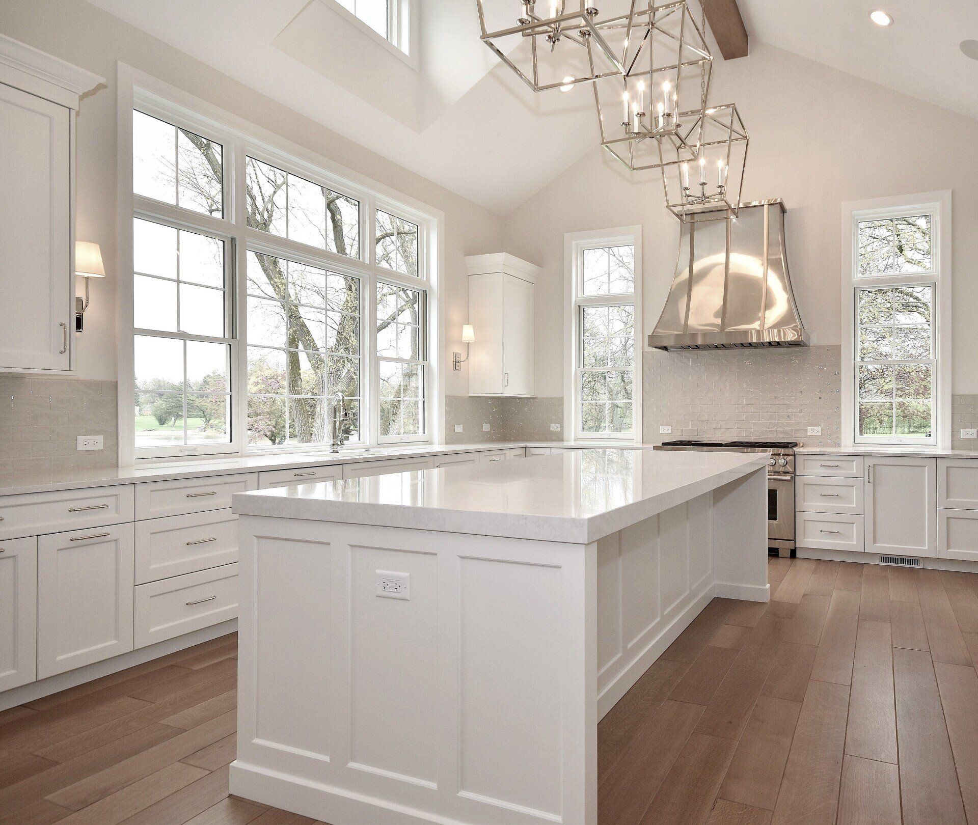 A kitchen with white cabinets and a large island