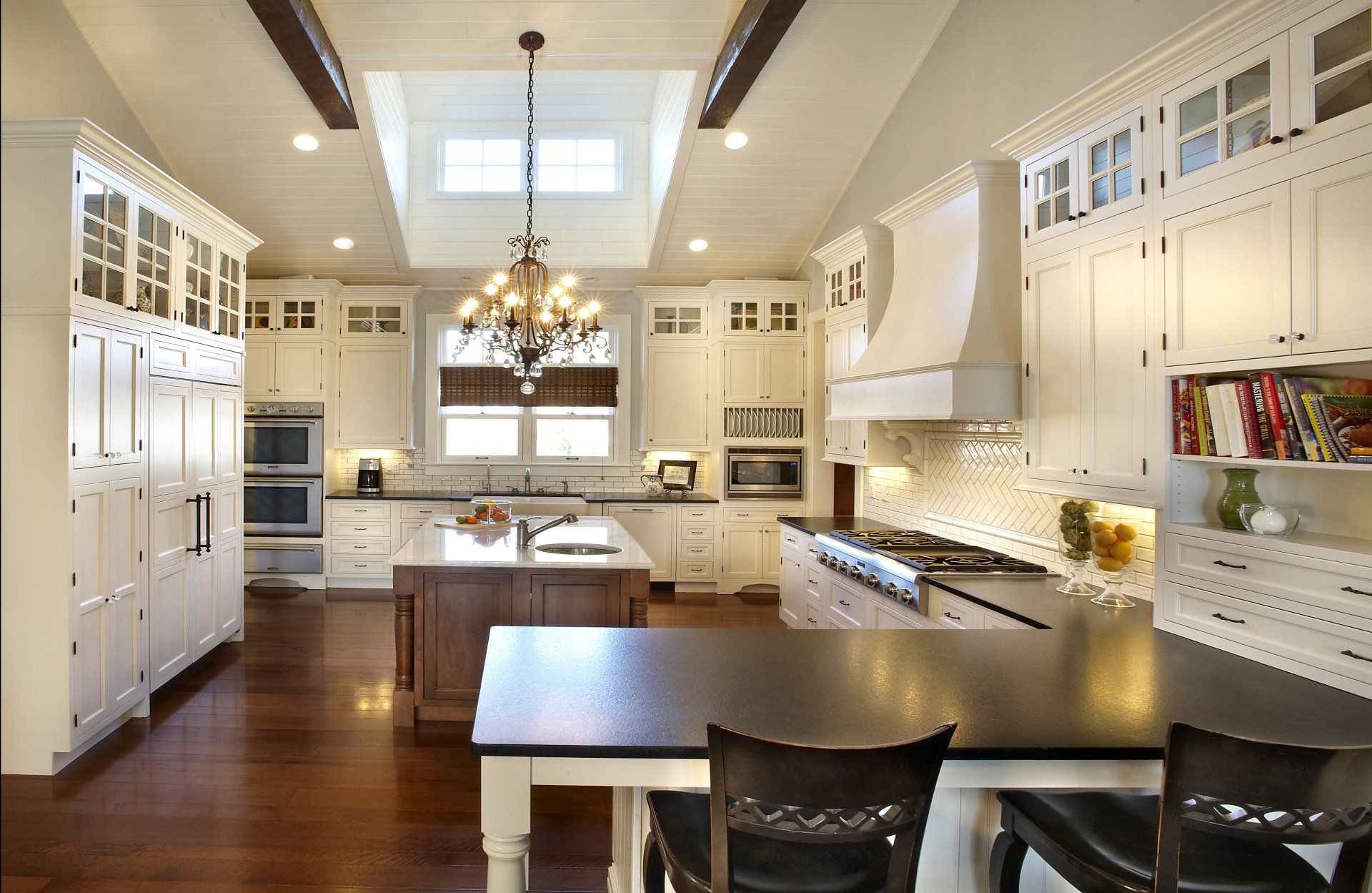 A kitchen with white cabinets and black counter tops