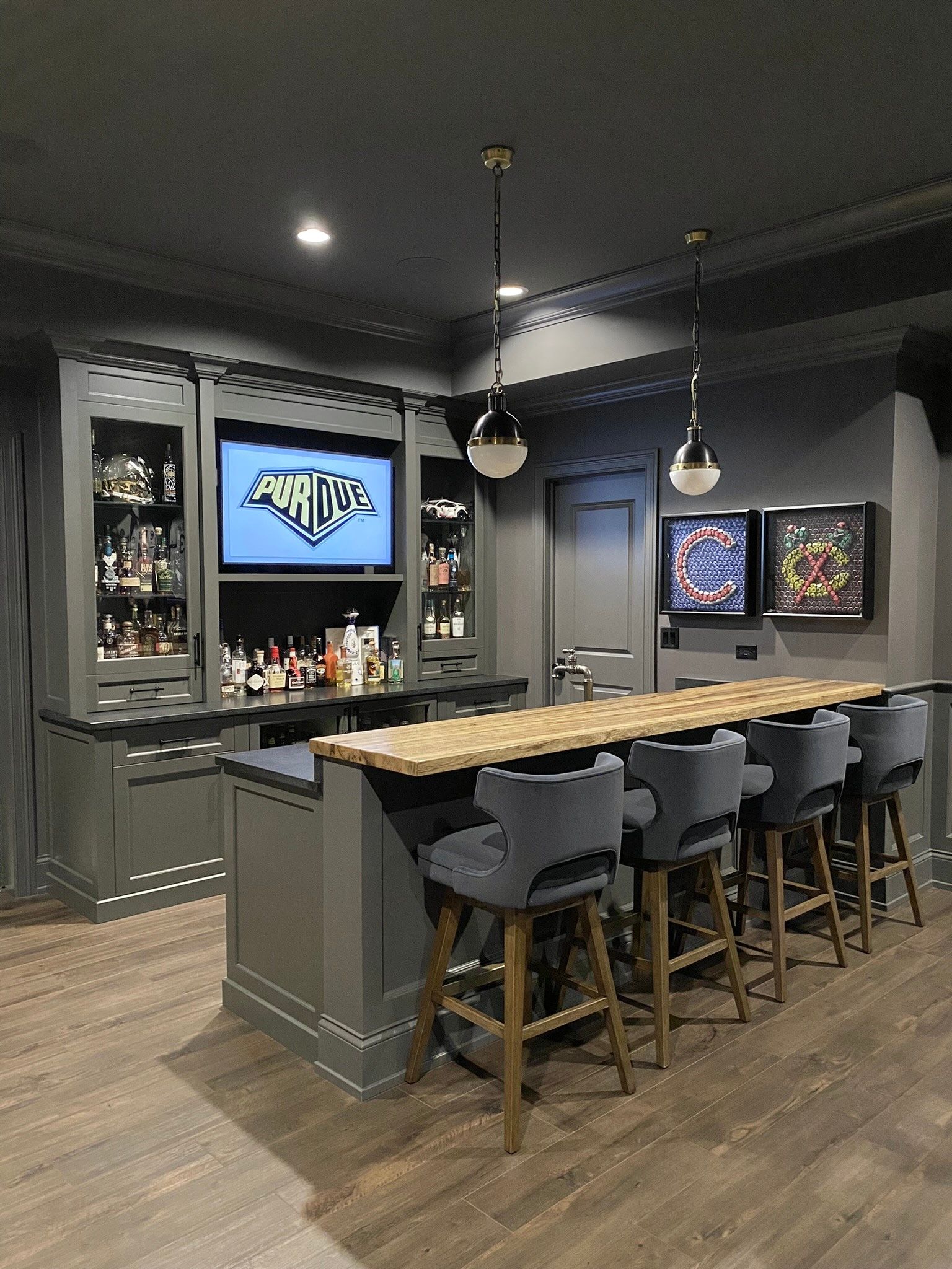 A basement bar with a long wooden table and stools.