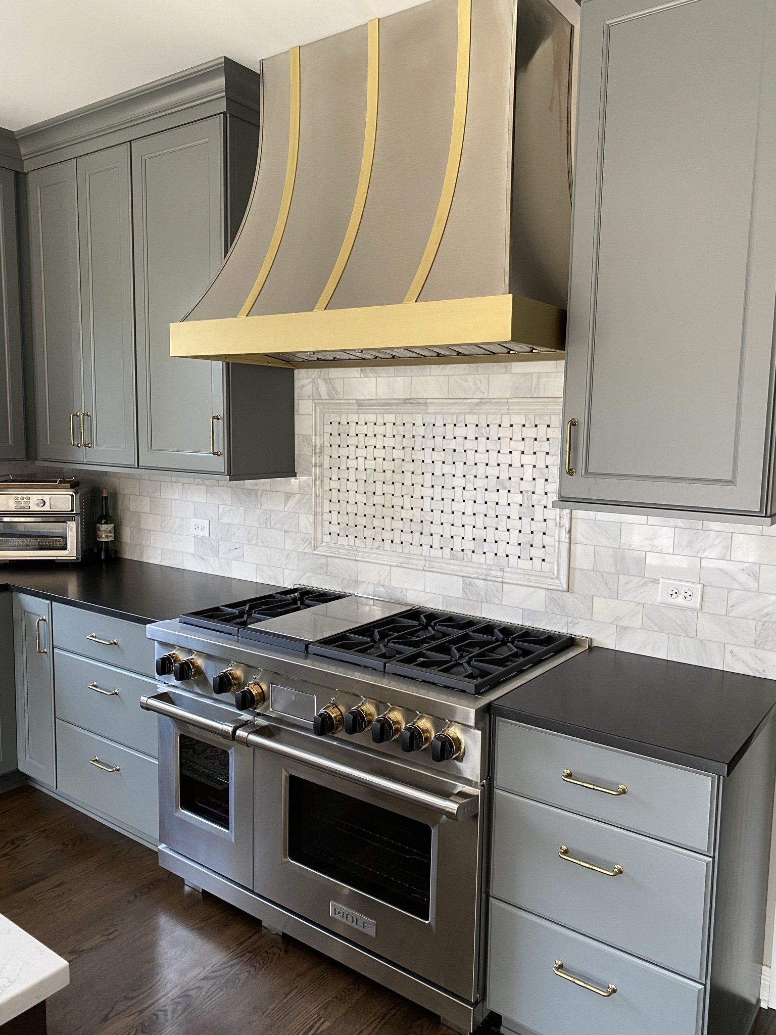 A kitchen with a stove top oven and a hood above it.