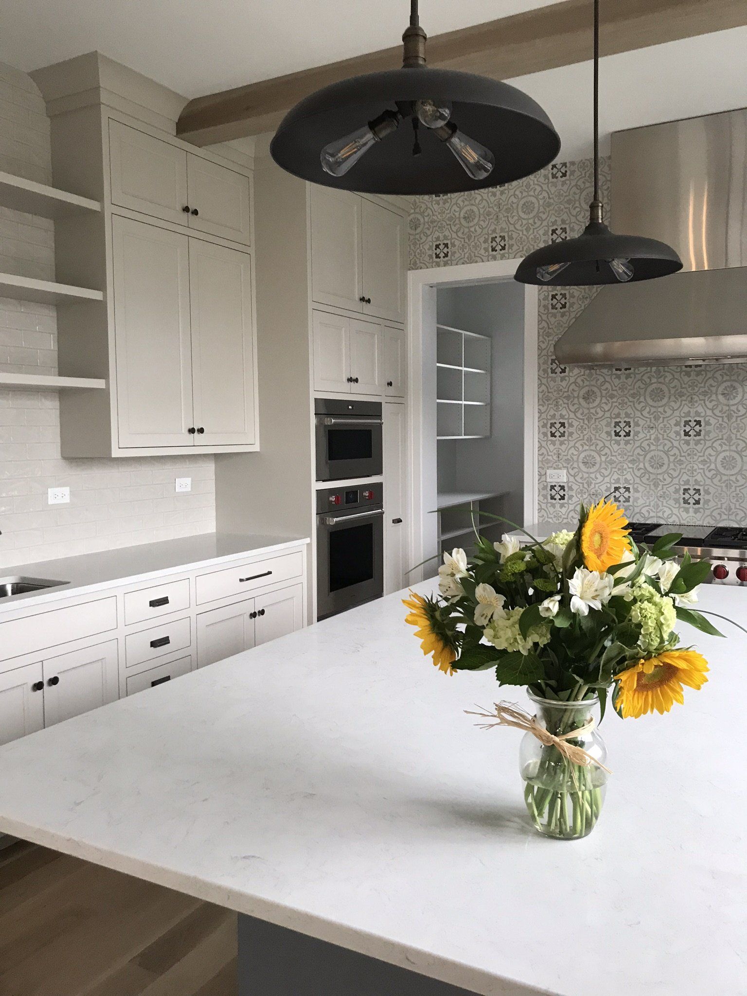 A kitchen with a vase of flowers on the counter.