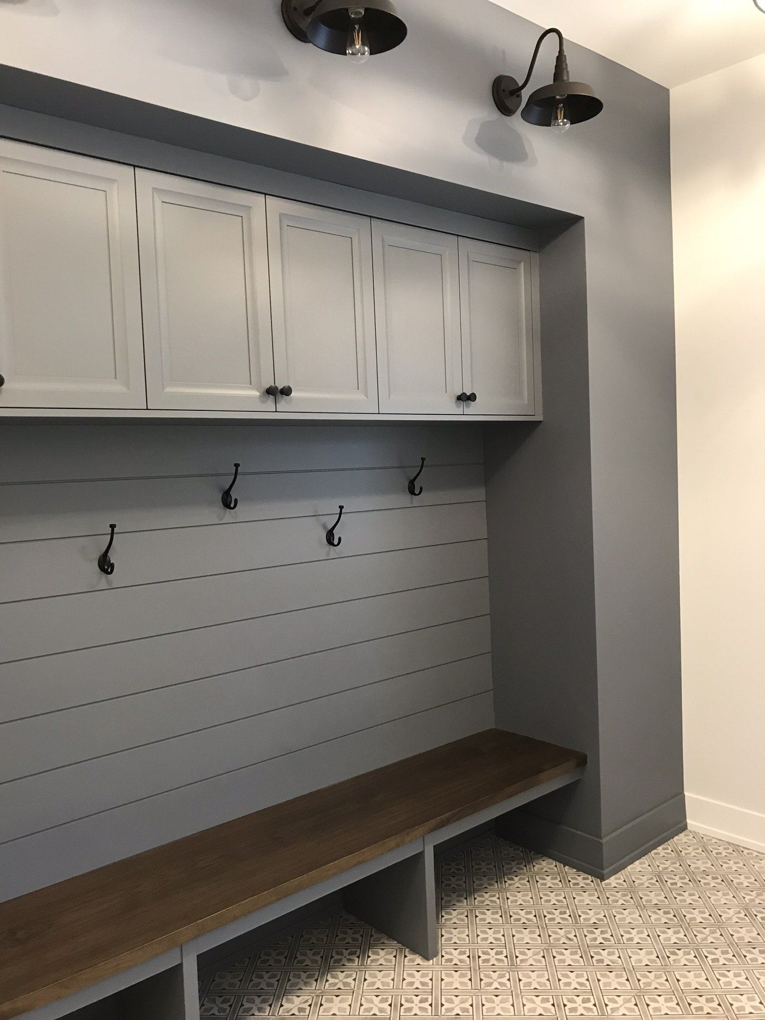 A room with a bench and hooks on the wall