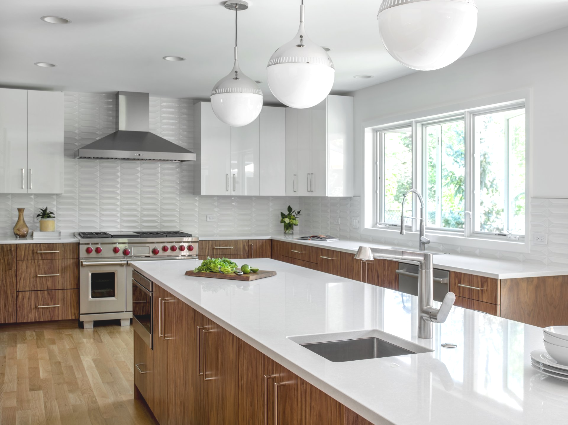 A kitchen with white cabinets , a stove , a sink , and a large island.