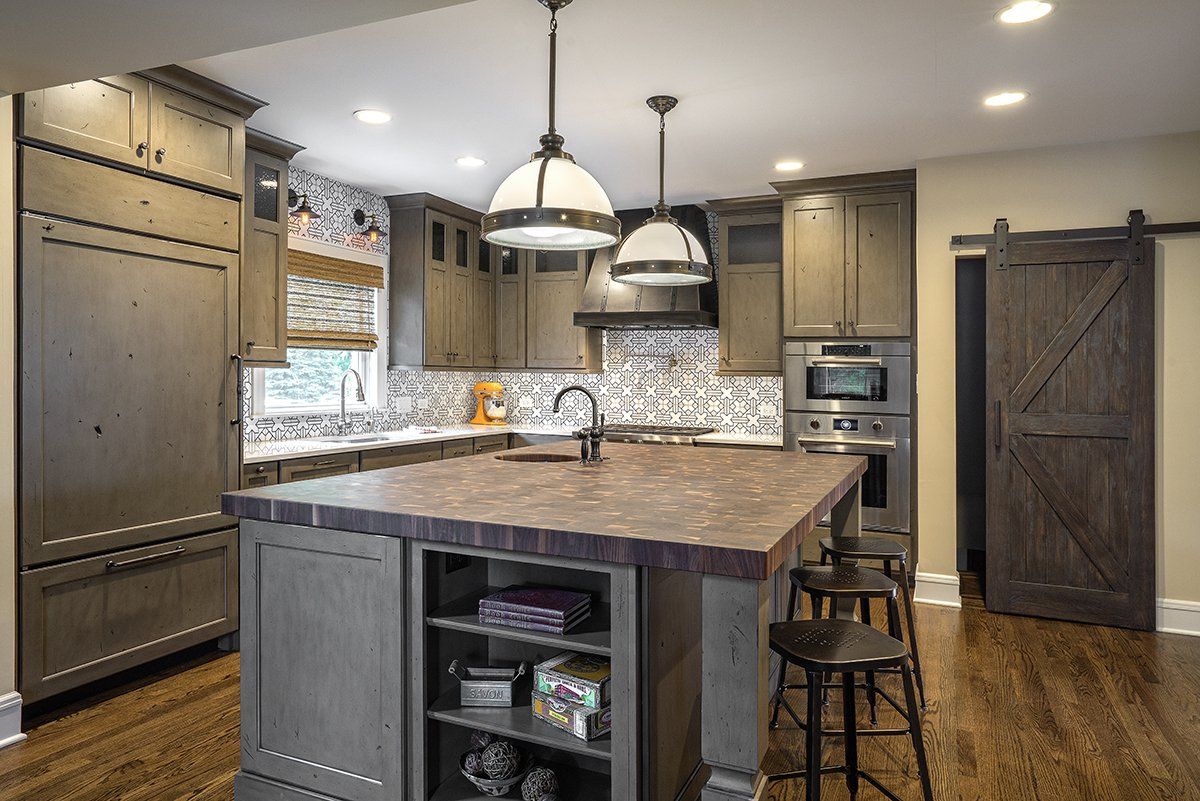 A kitchen with a large island in the middle and a sliding barn door.