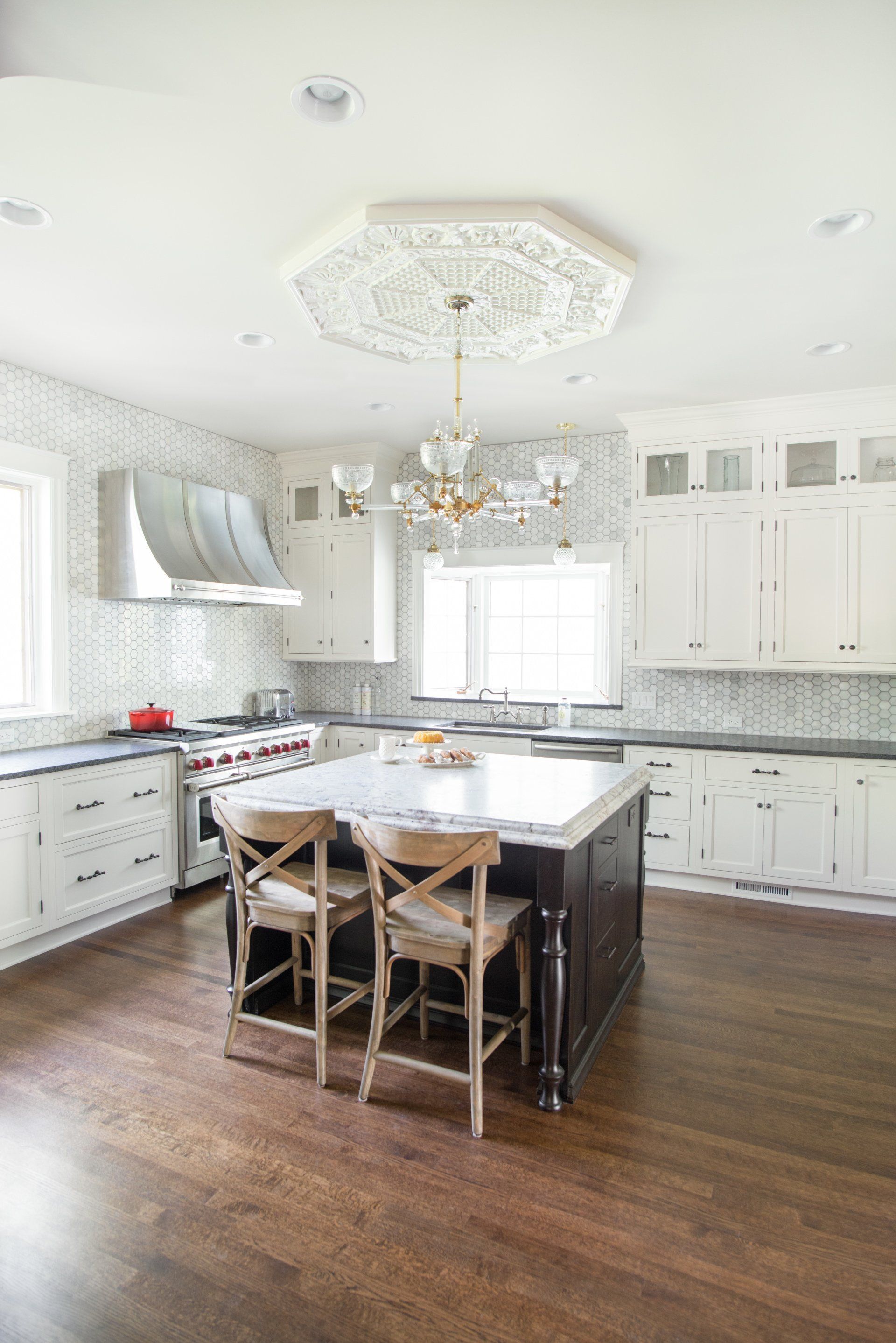 A kitchen with white cabinets and a large island in the middle.