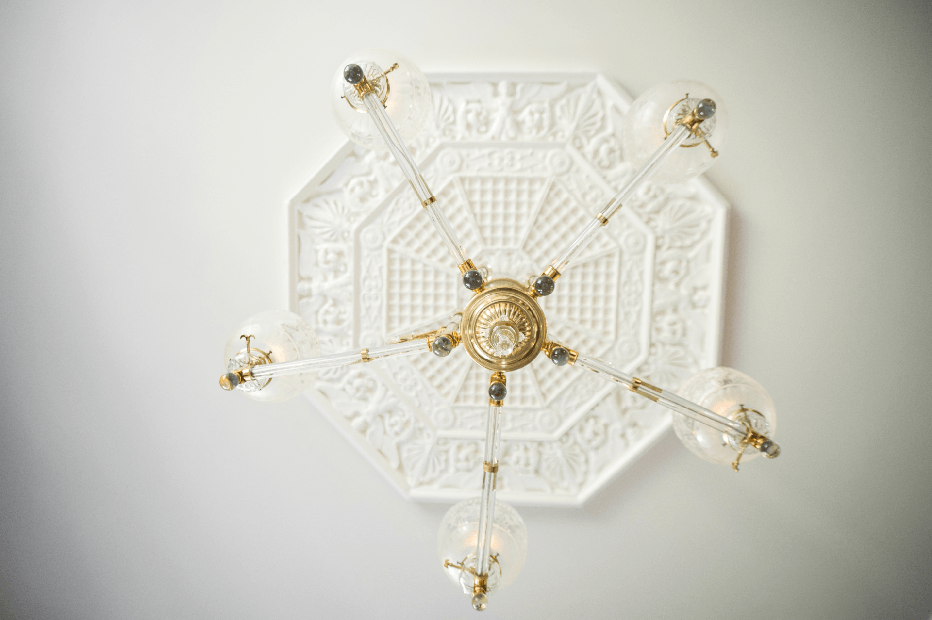 A chandelier is hanging from the ceiling on a white wall.