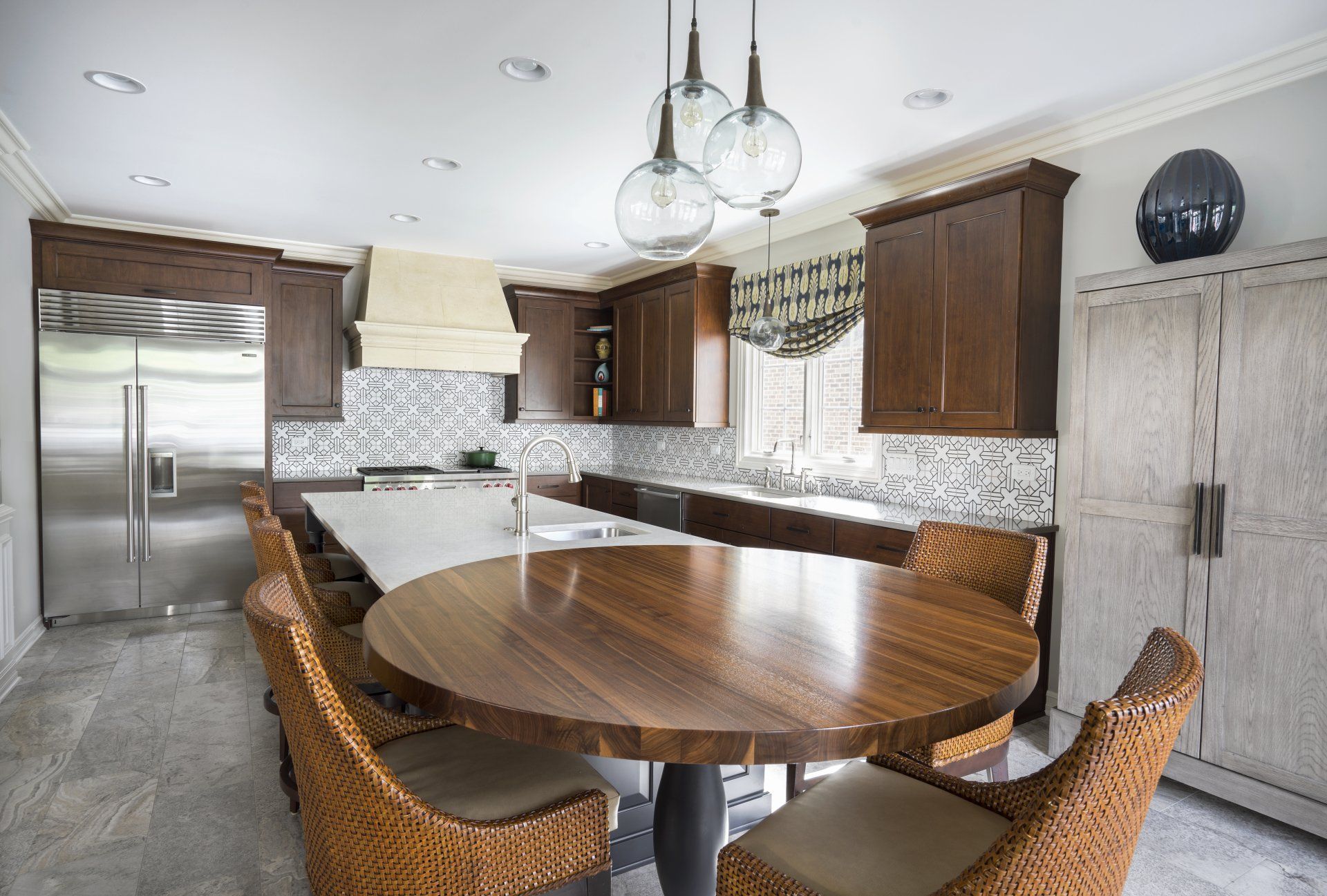 A kitchen with a round wooden table and wicker chairs
