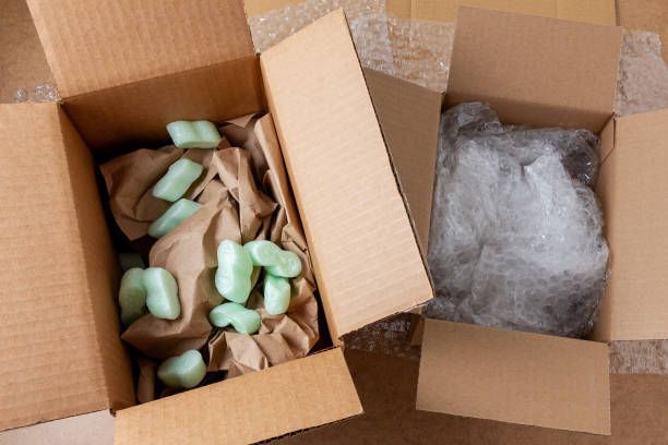 Packing supplies, including cardboard boxes, packing peanuts, and bubble wrap.