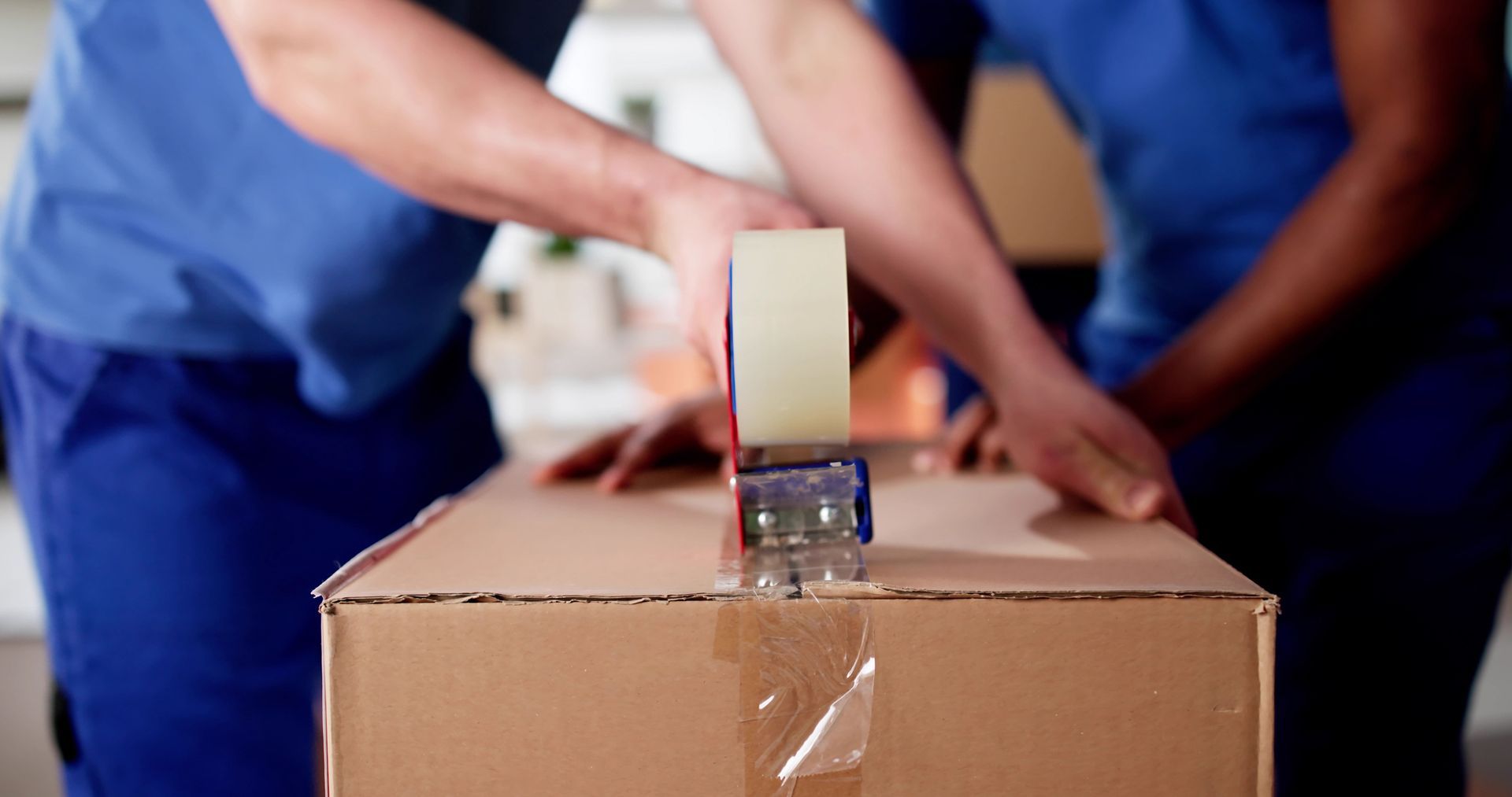 Movers carefully packing items in moving boxes for a residential move.