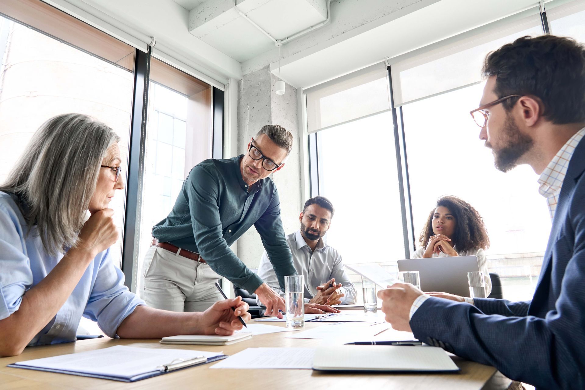 a group of people are sitting around a table having a meeting