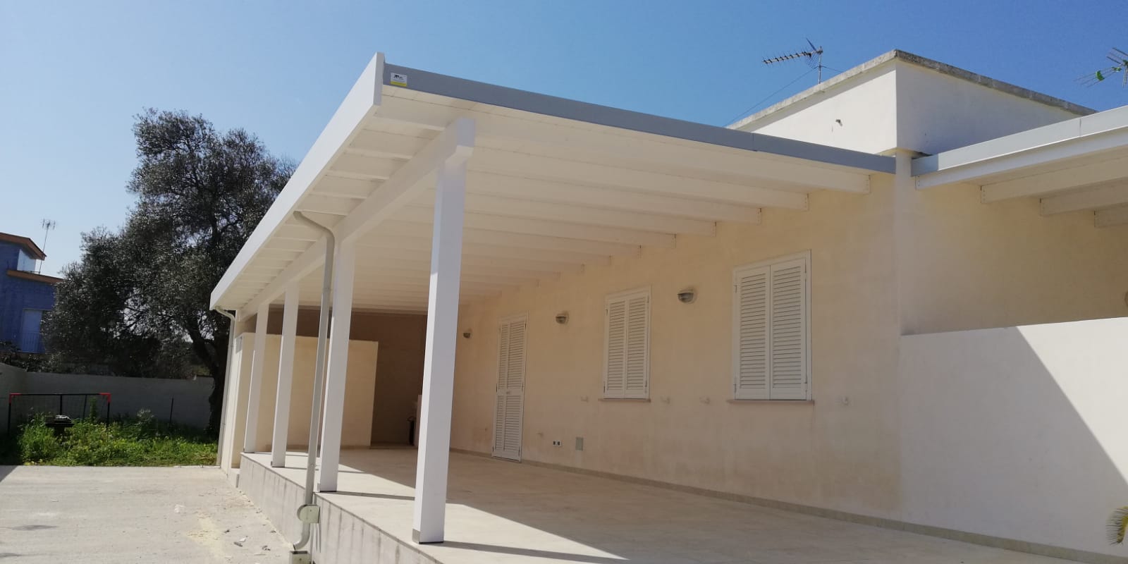 Tettoia con fascia frontale stile moderno e con gronda incassata all’interno tutta bianco decapè