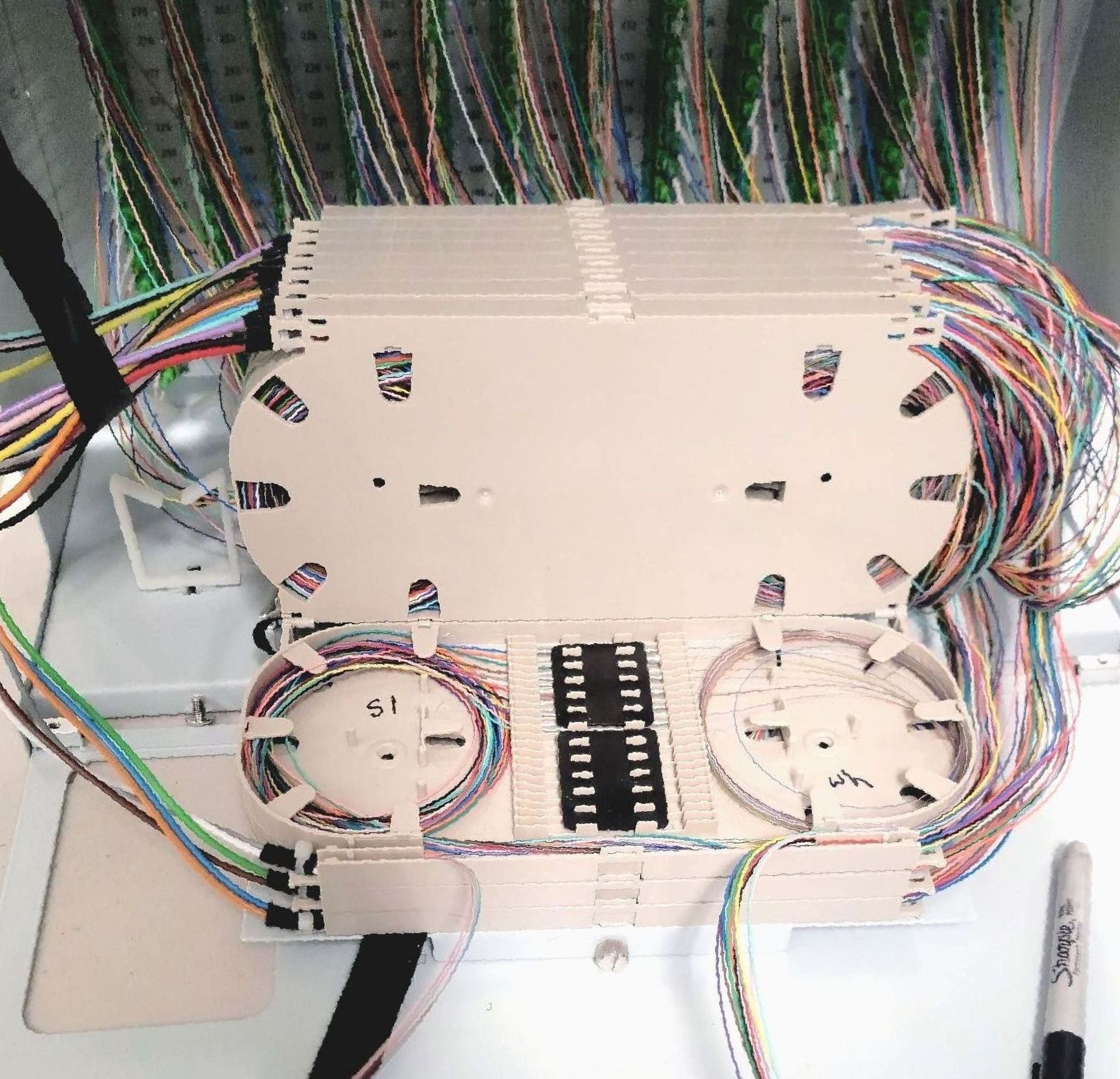 A bunch of wires are connected to a white box