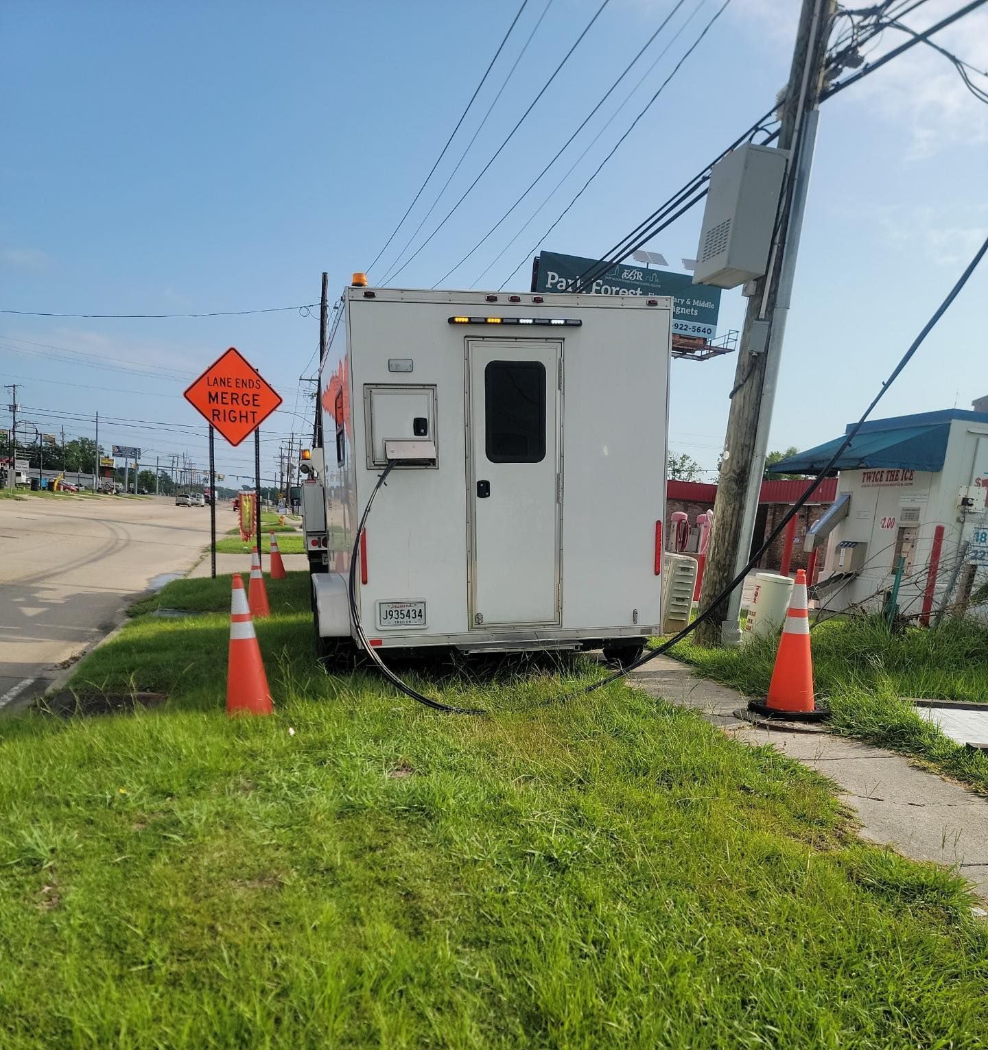 A white trailer is parked on the side of the road