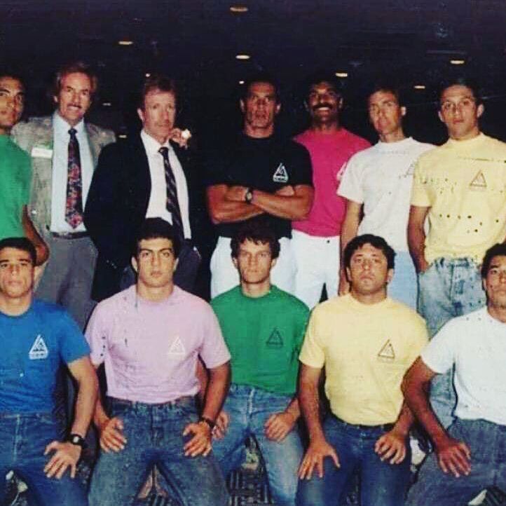 A group of men are posing for a picture and one of them has a triangle on his shirt