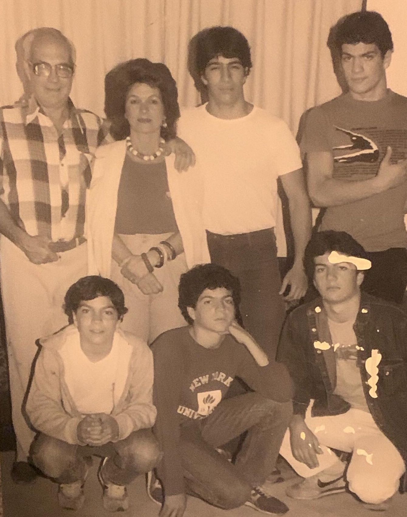 A group of people posing for a picture with one wearing a sweatshirt that says new york on it