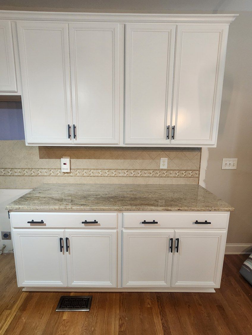 A kitchen with white cabinets and a granite counter top.