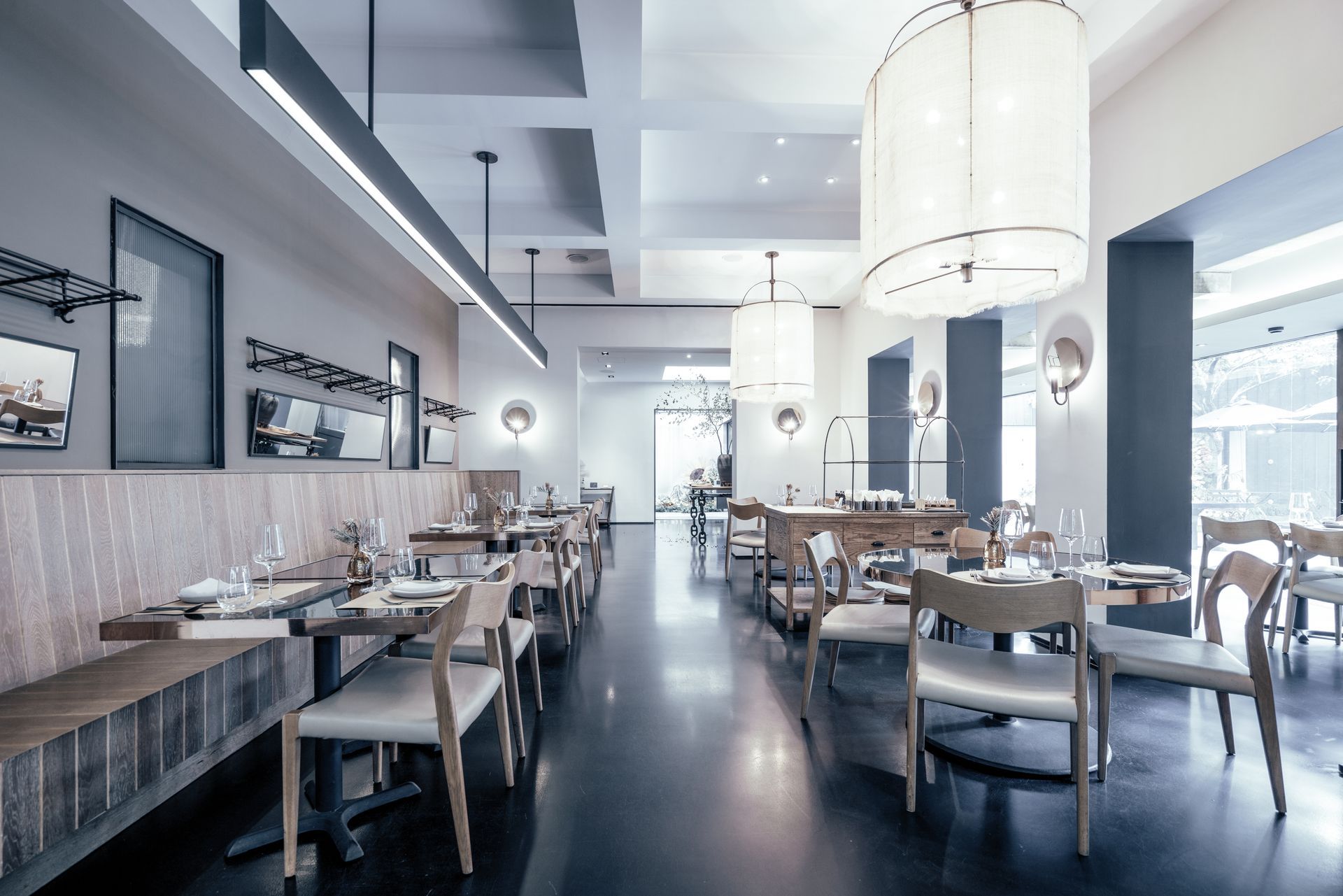 A restaurant with tables and chairs and a chandelier hanging from the ceiling.