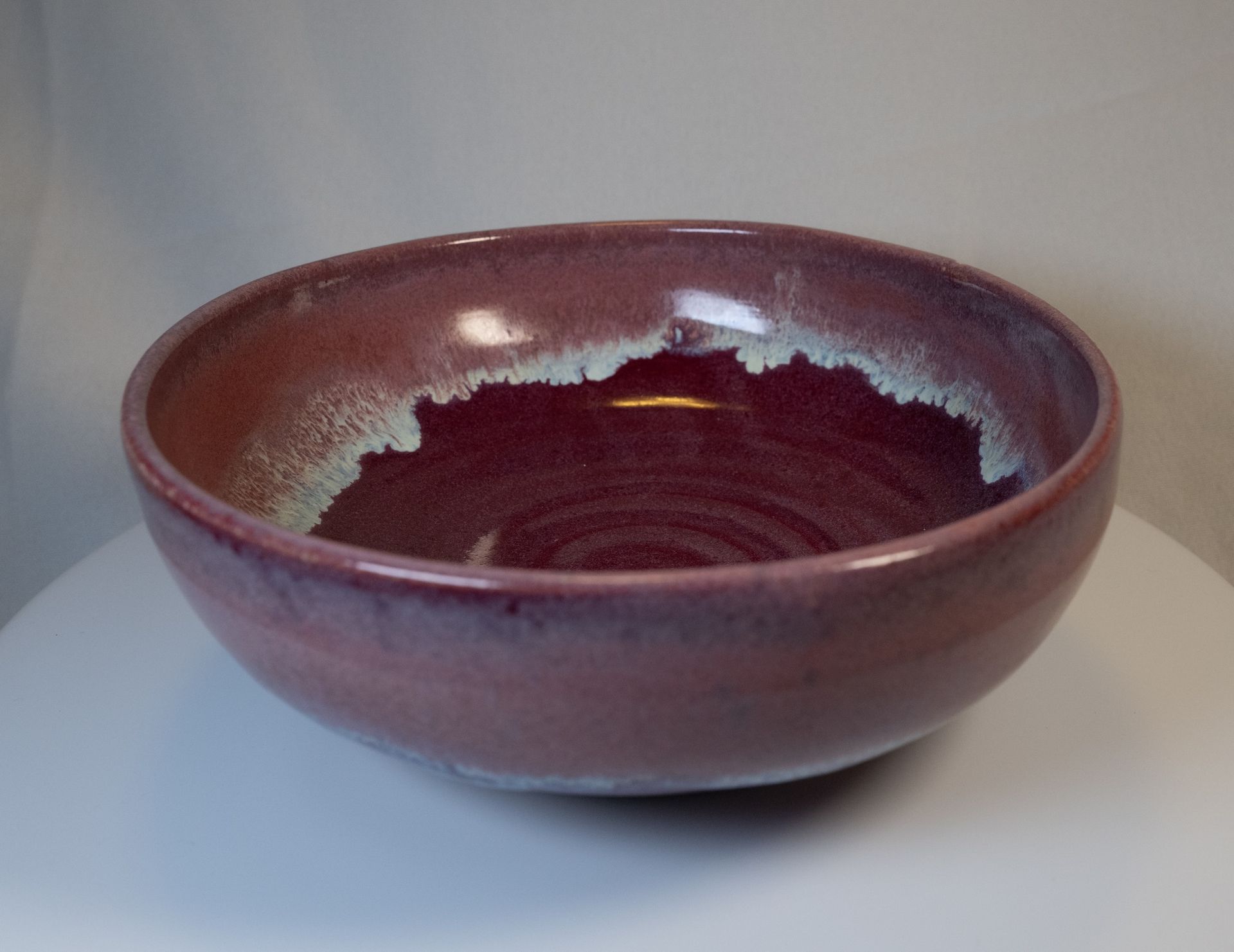 Ceramic bowl, deep burgundy with lighter rim.