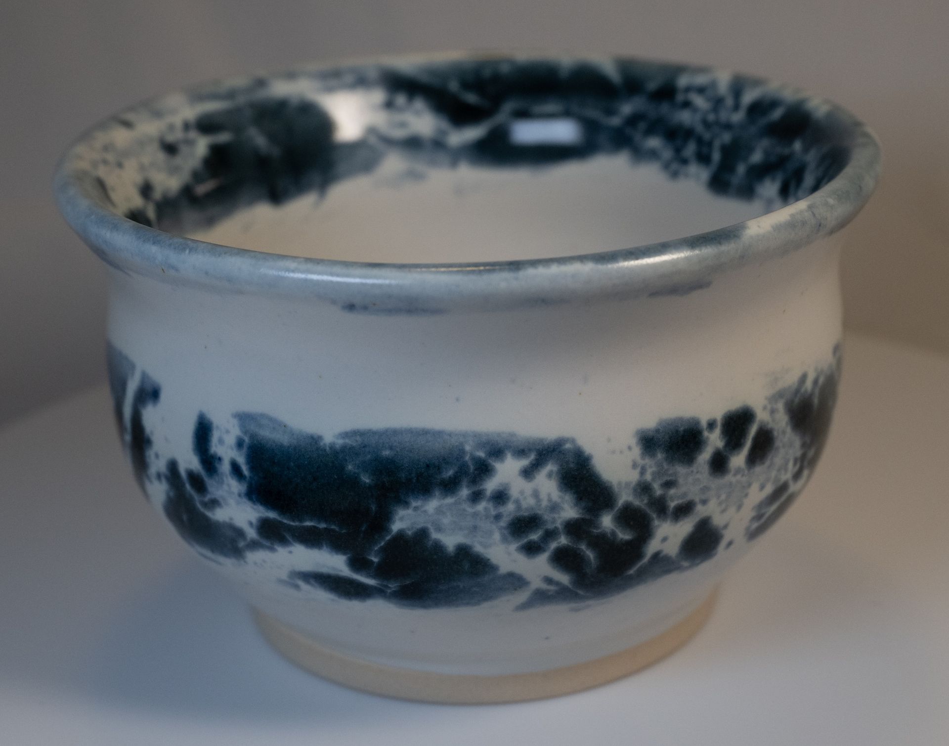 White ceramic bowl with blue, swirling, wave-like design.