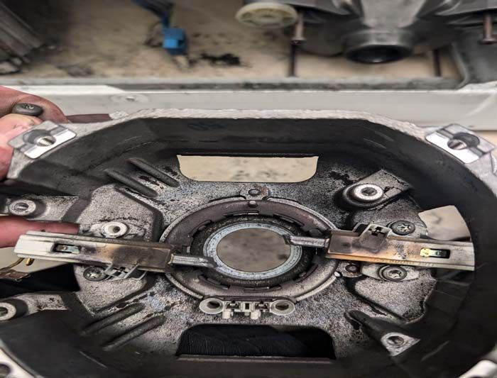 Open view of a dark, circular motor part with metal and ceramic components, showing signs of wear.