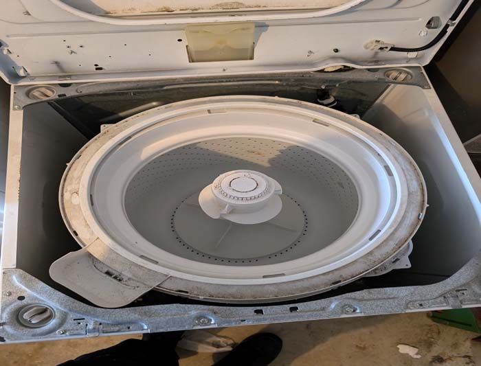 White washing machine with the lid open, showing the empty drum.