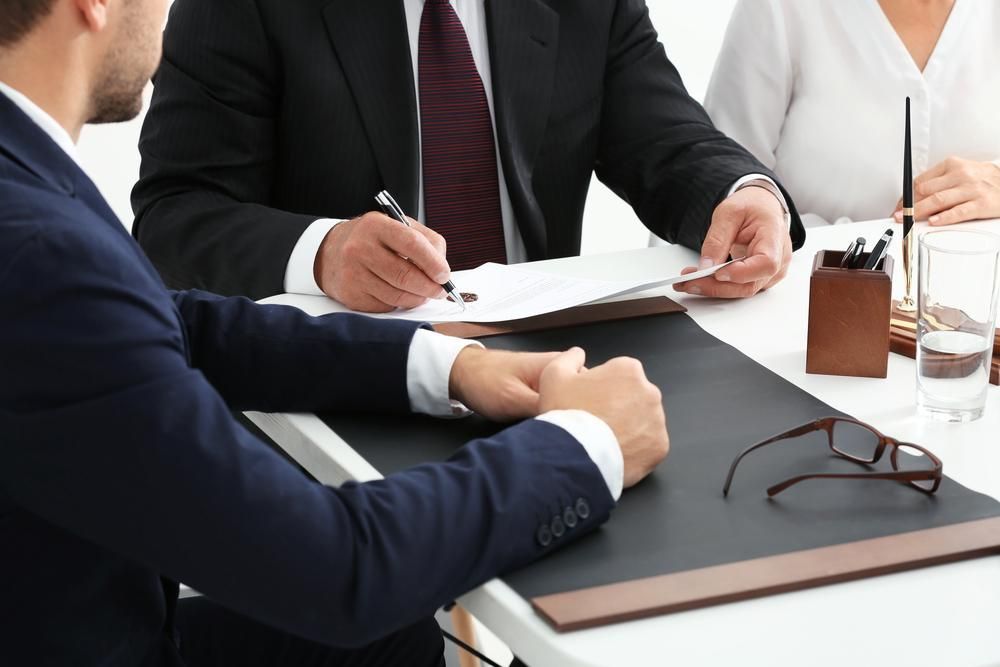 A Group Of Business People Are Sitting At A Table Having A Meeting — Coast & Country Insurance Consultants Pty Ltd In Central Coast, NSW