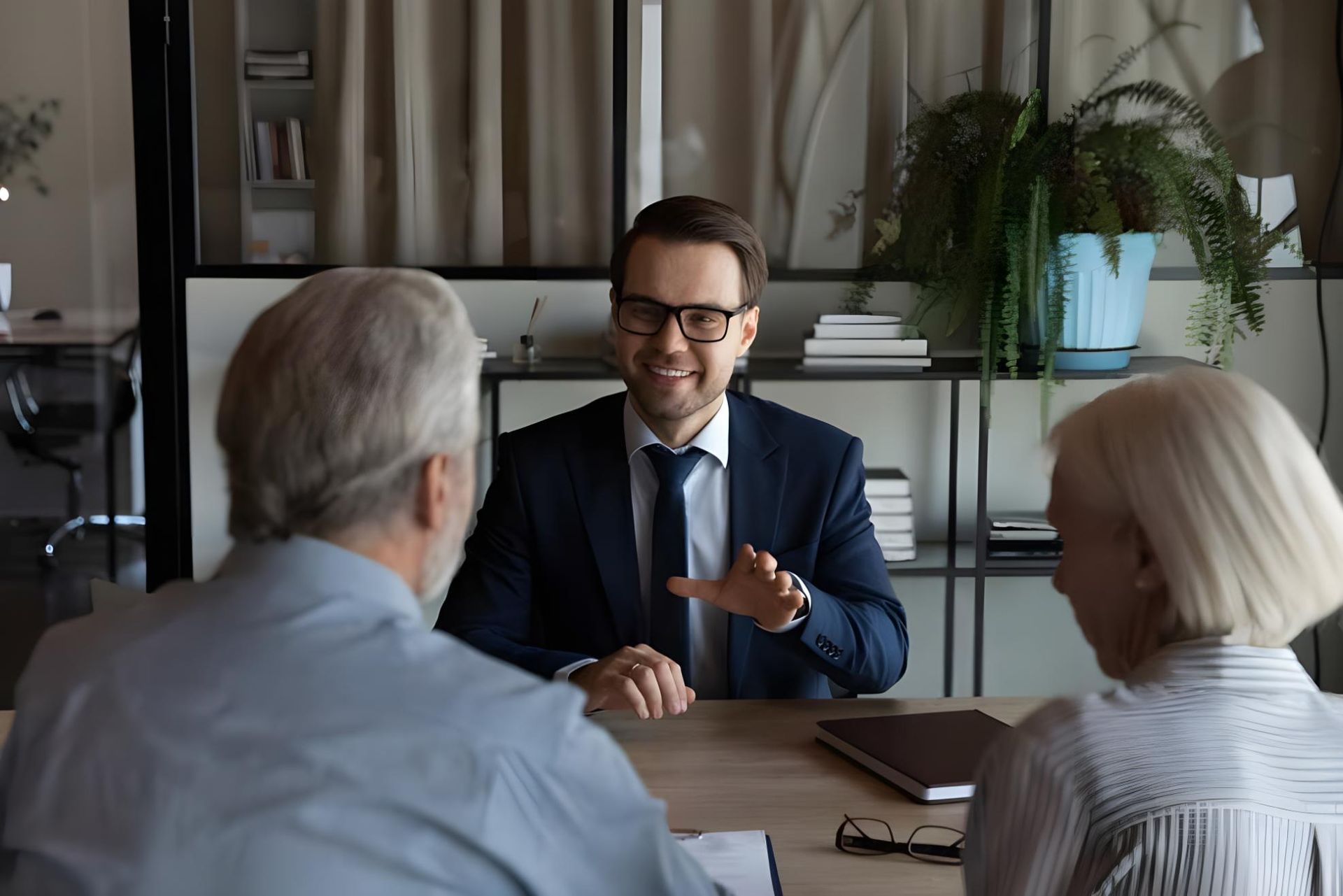 a Group of People Are Sitting Around a Table With Laptops and Tablets — Coast & Country Insurance Consultants Pty Ltd In Central Coast, NSW