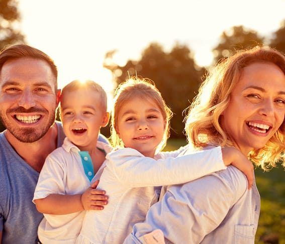 A family is posing for a picture together in a park.