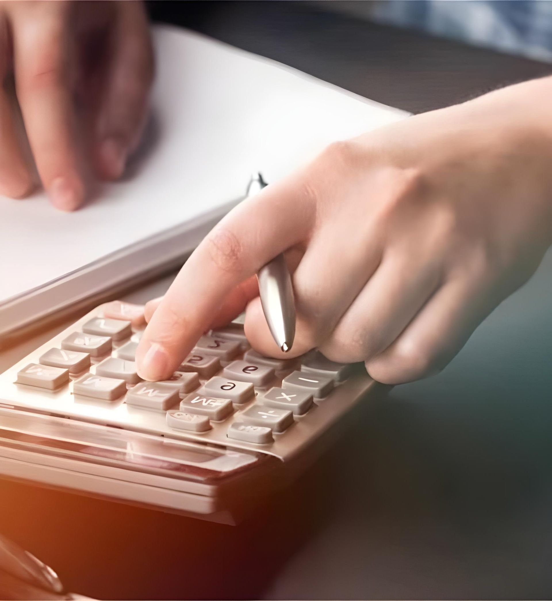 A Person Is Using A Calculator With A Pen In Their Hand — Coast & Country Insurance Consultants Pty Ltd In Central Coast, NSW