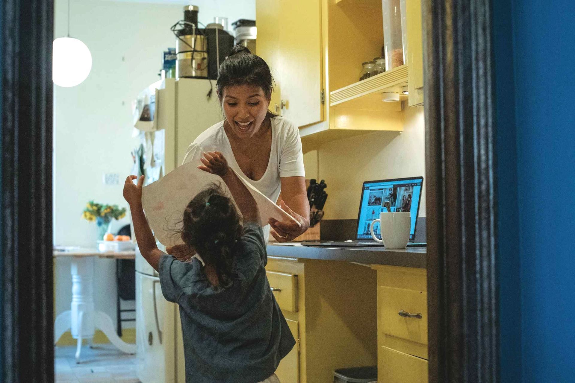 a Woman and a Child Are Playing in a Kitchen — Coast & Country Insurance Consultants Pty Ltd In Central Coast, NSW