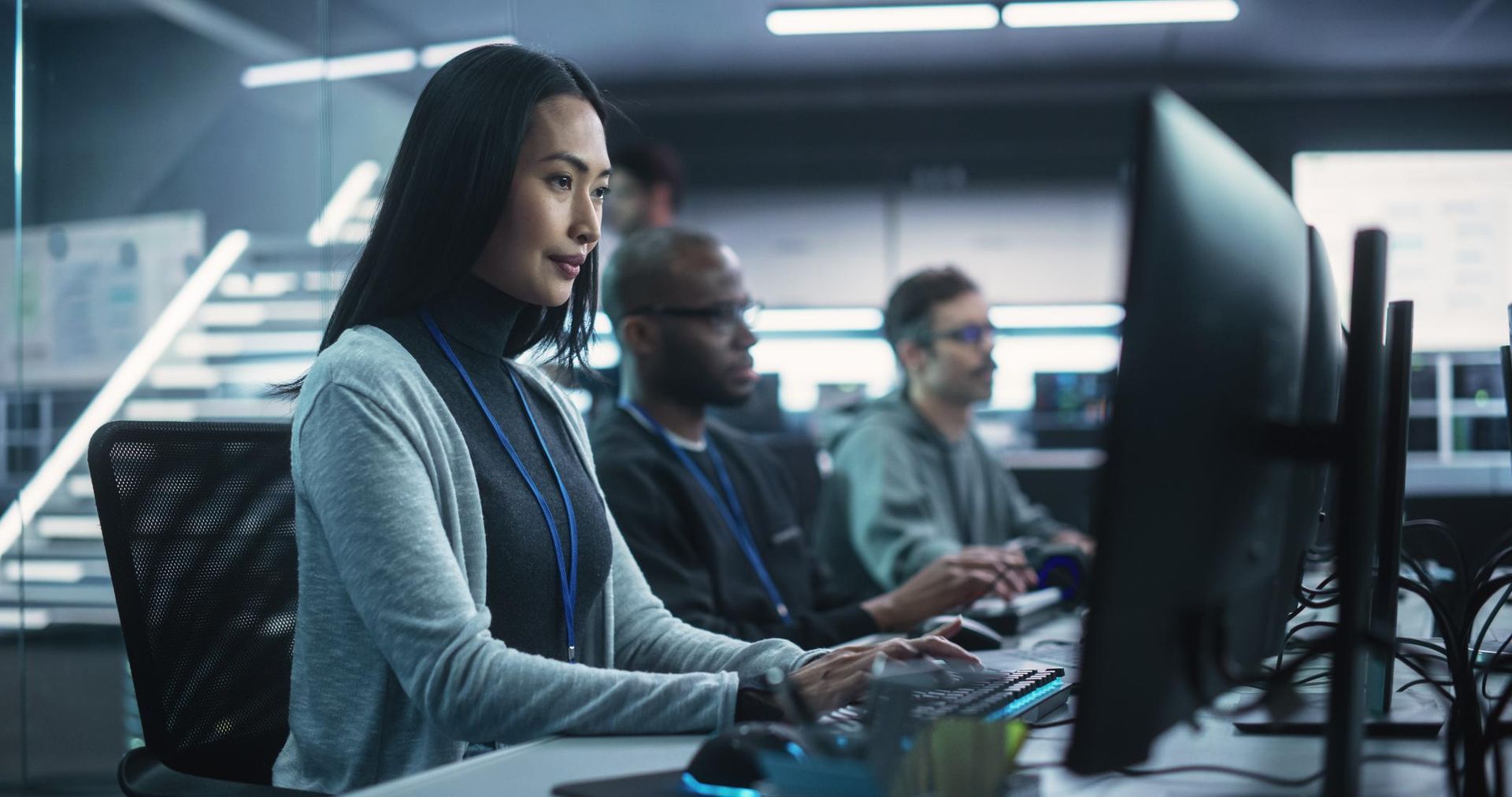 A woman is sitting at a desk in front of a computer.