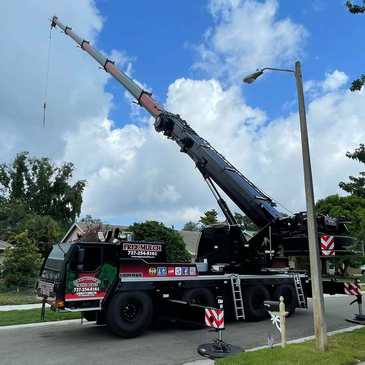 A large crane is parked on the side of the road