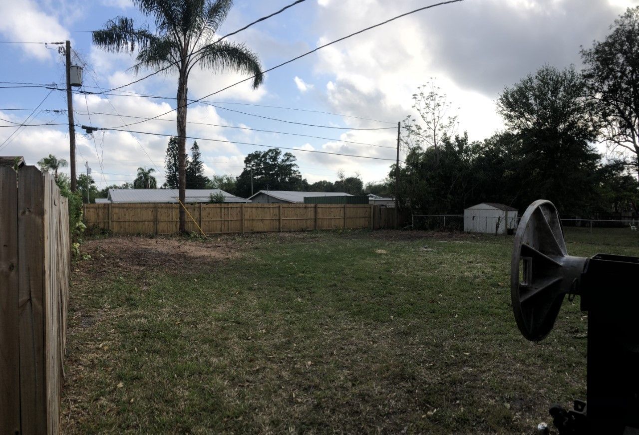 A large house with a garage and trees in front of it