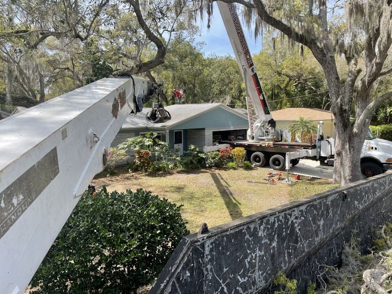 A crane is working on the roof of a house.