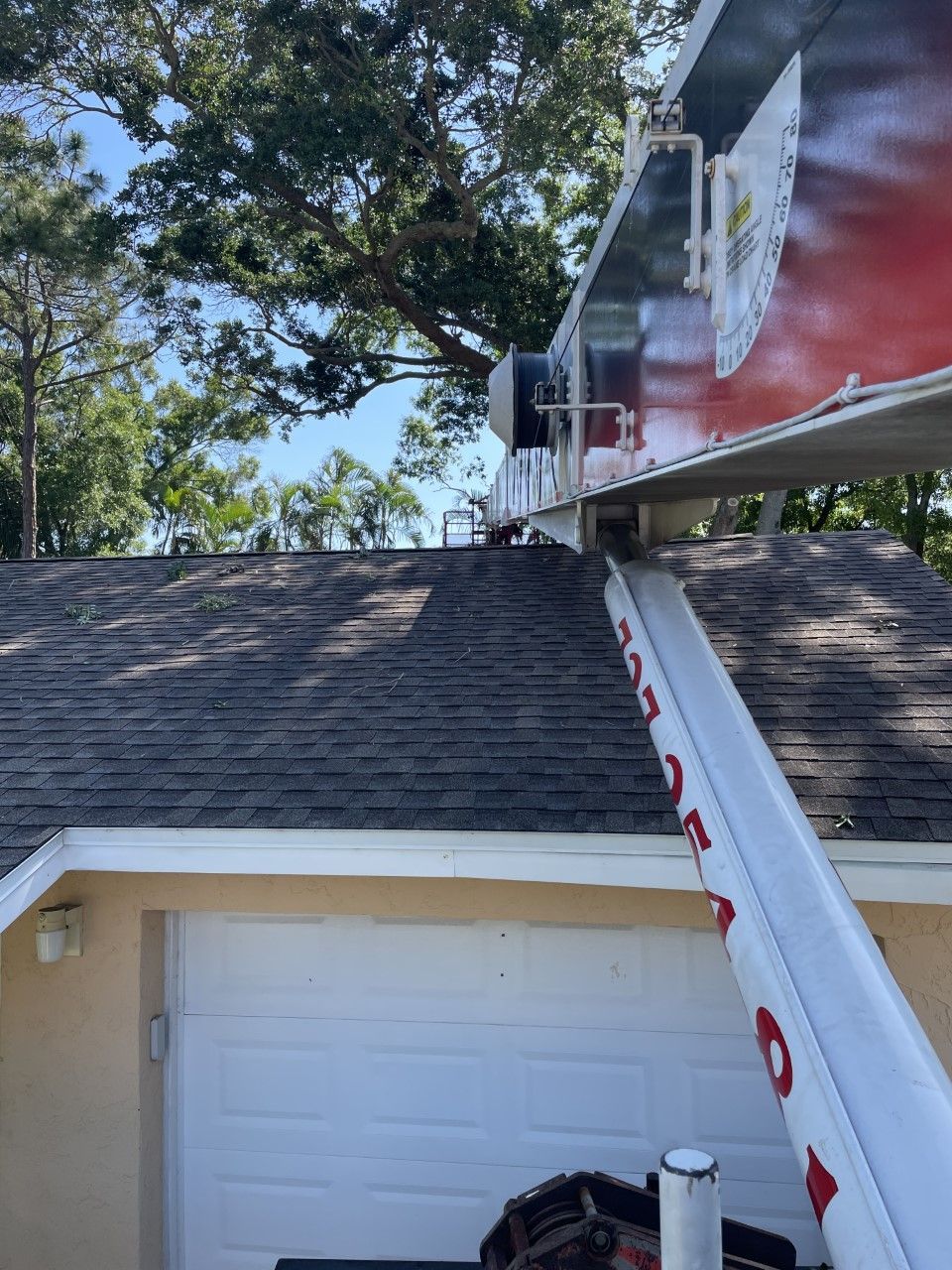 A ladder is going up to the roof of a house.