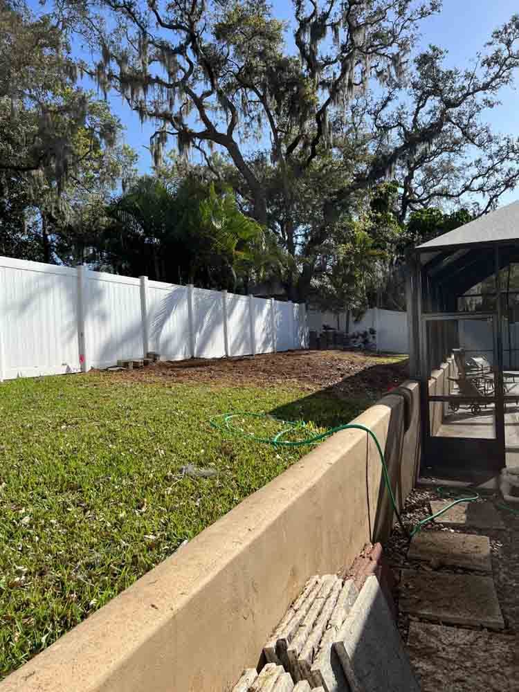 A backyard with a white fence and a gazebo.
