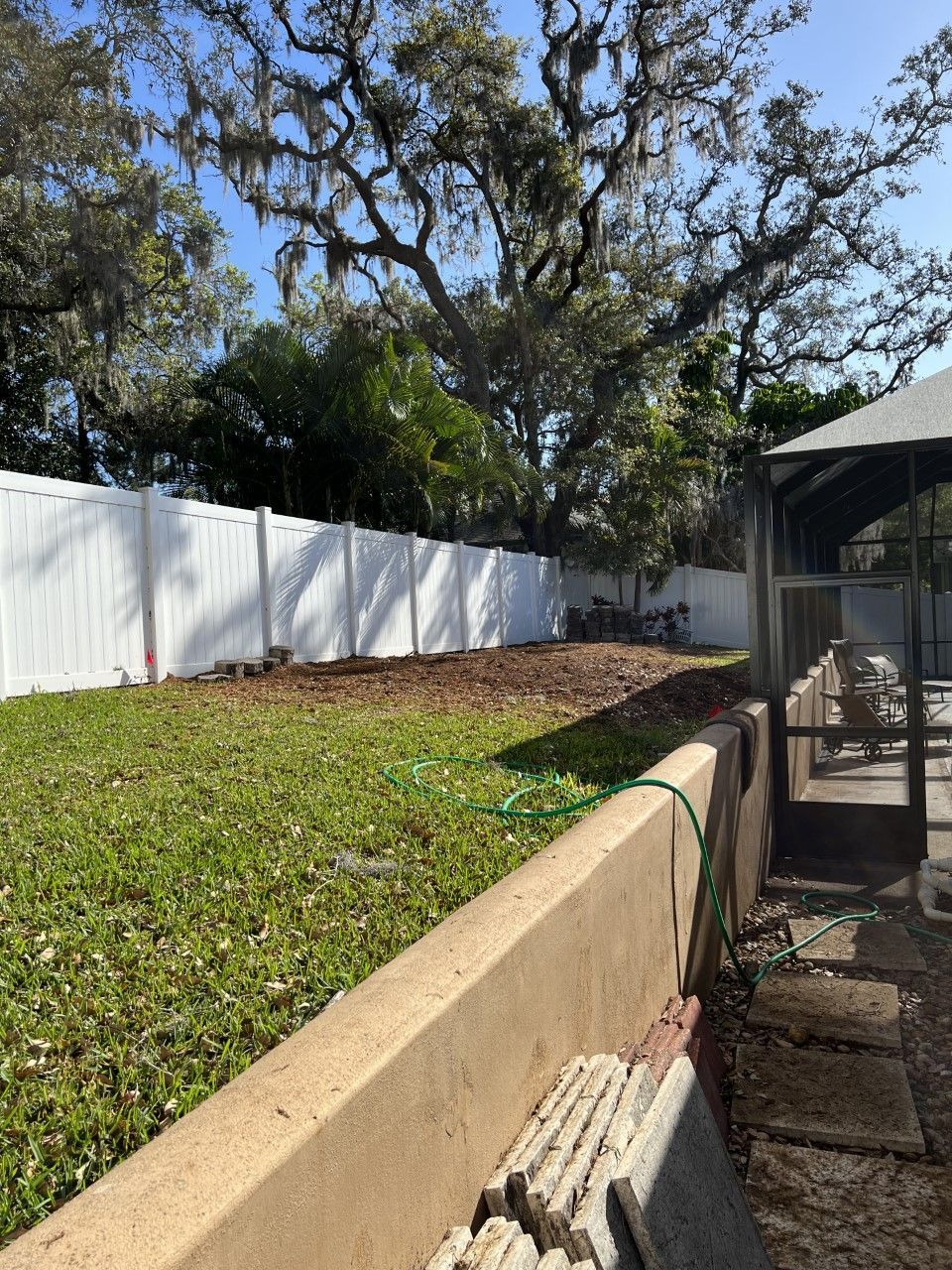A backyard with a white fence and a gazebo.