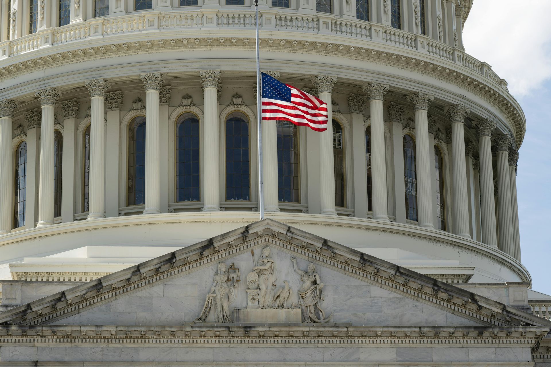 The U.S. Capitol building with the American flag waving in the foreground