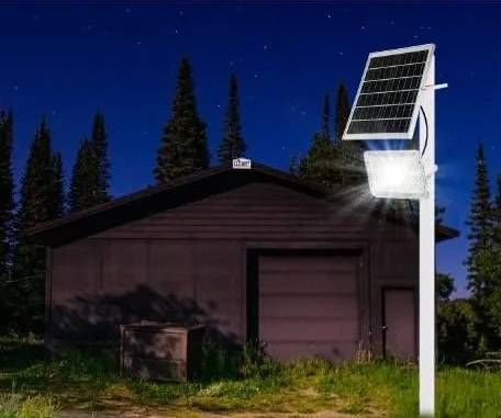 Un panel solar está situado encima de un poste frente a un garaje.