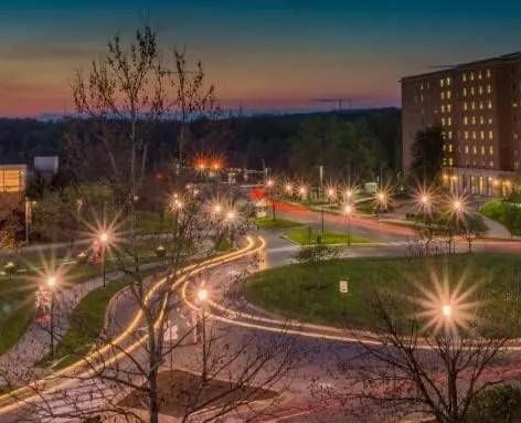 Una vista aérea de una calle de la ciudad por la noche con un edificio al fondo.