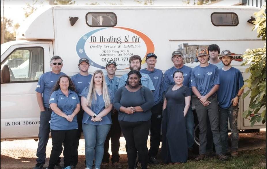 jd heating & air team standing in front of a van that says jd heating & air