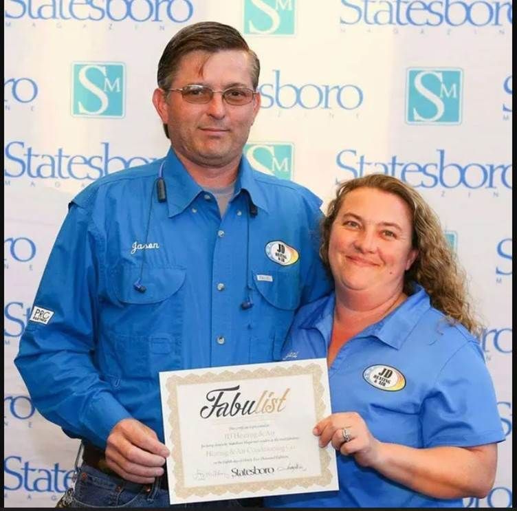 JD heating & air husband and wife owners holding a certificate that says fabulist