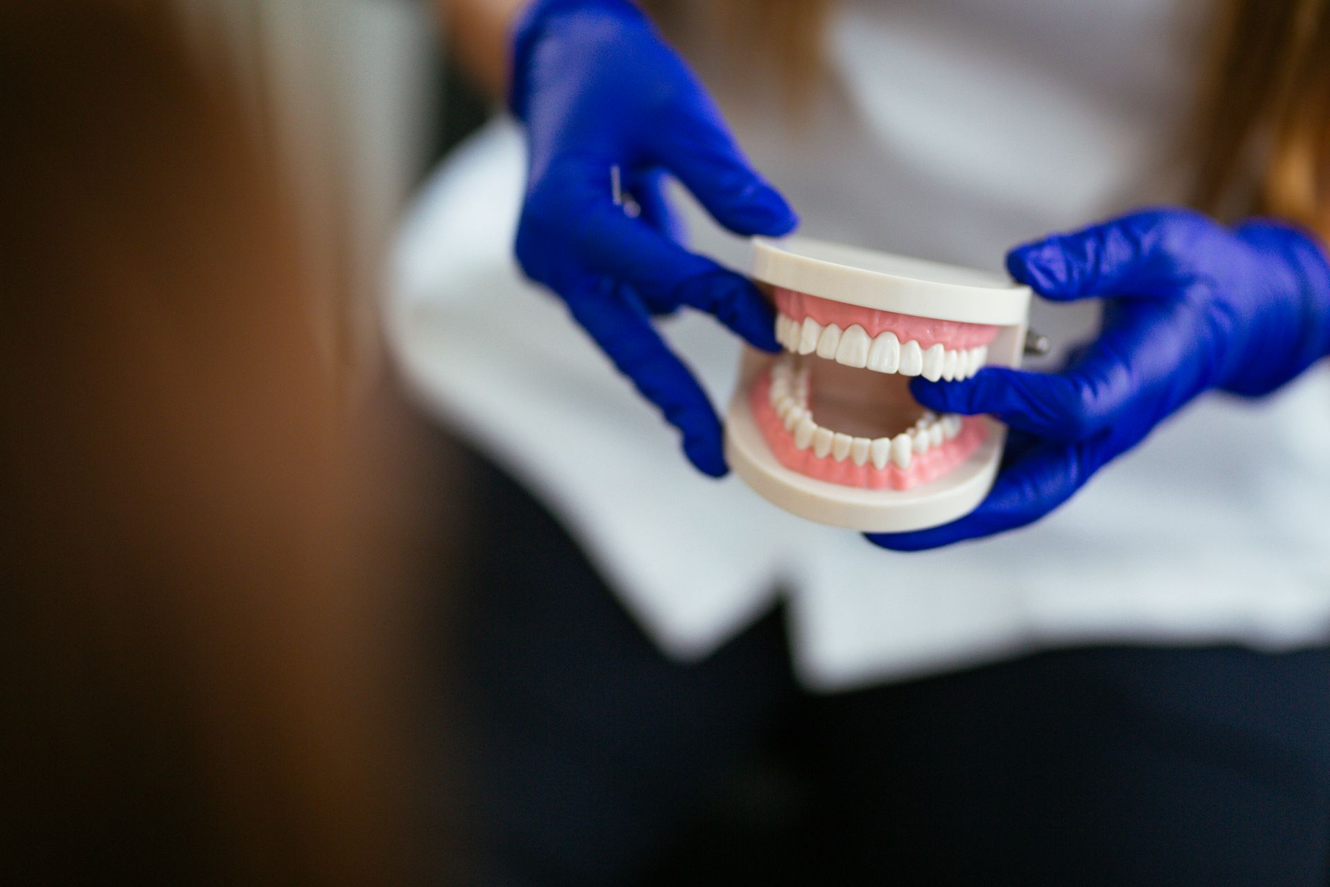 Close-up of dentist holding dentures during a dental exam.