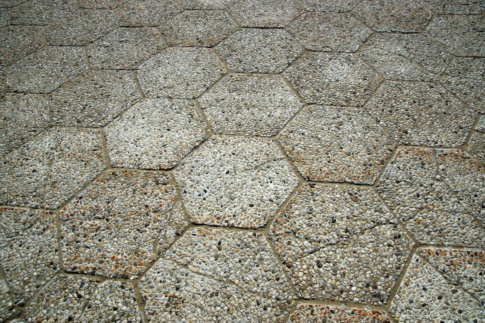 Hexagonal stone paving with light gray tiles and gravel gaps.