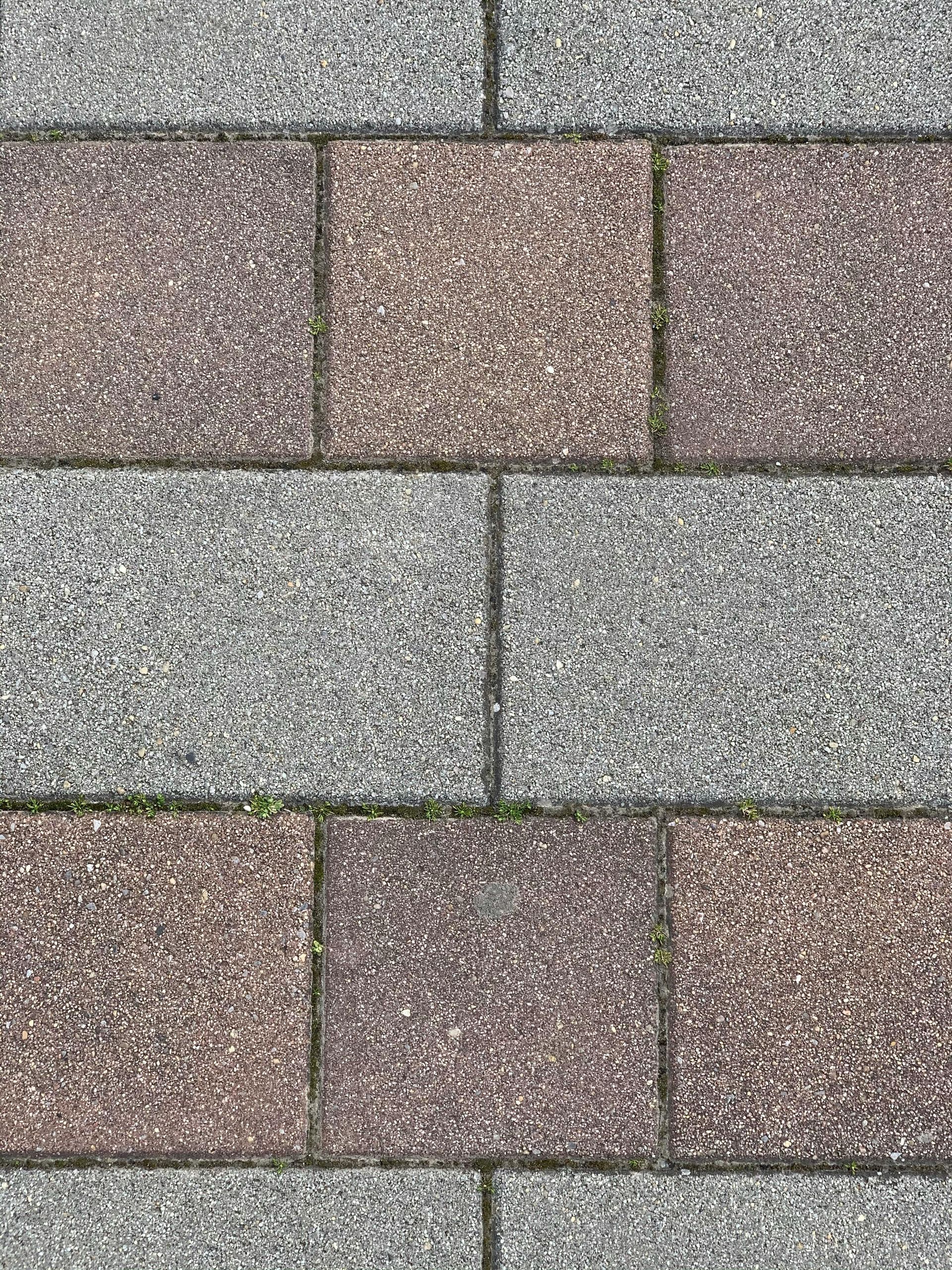 Close-up of multicolored stone pavers in a staggered brick pattern.