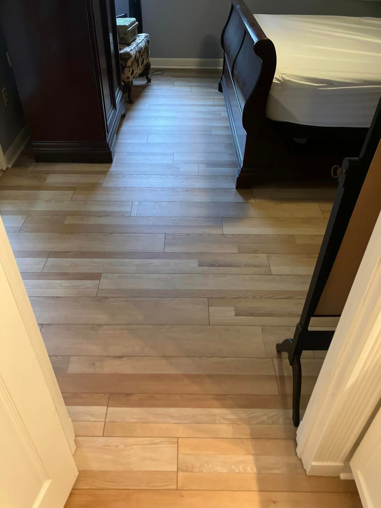 A bedroom with hardwood floors and a sleigh bed.