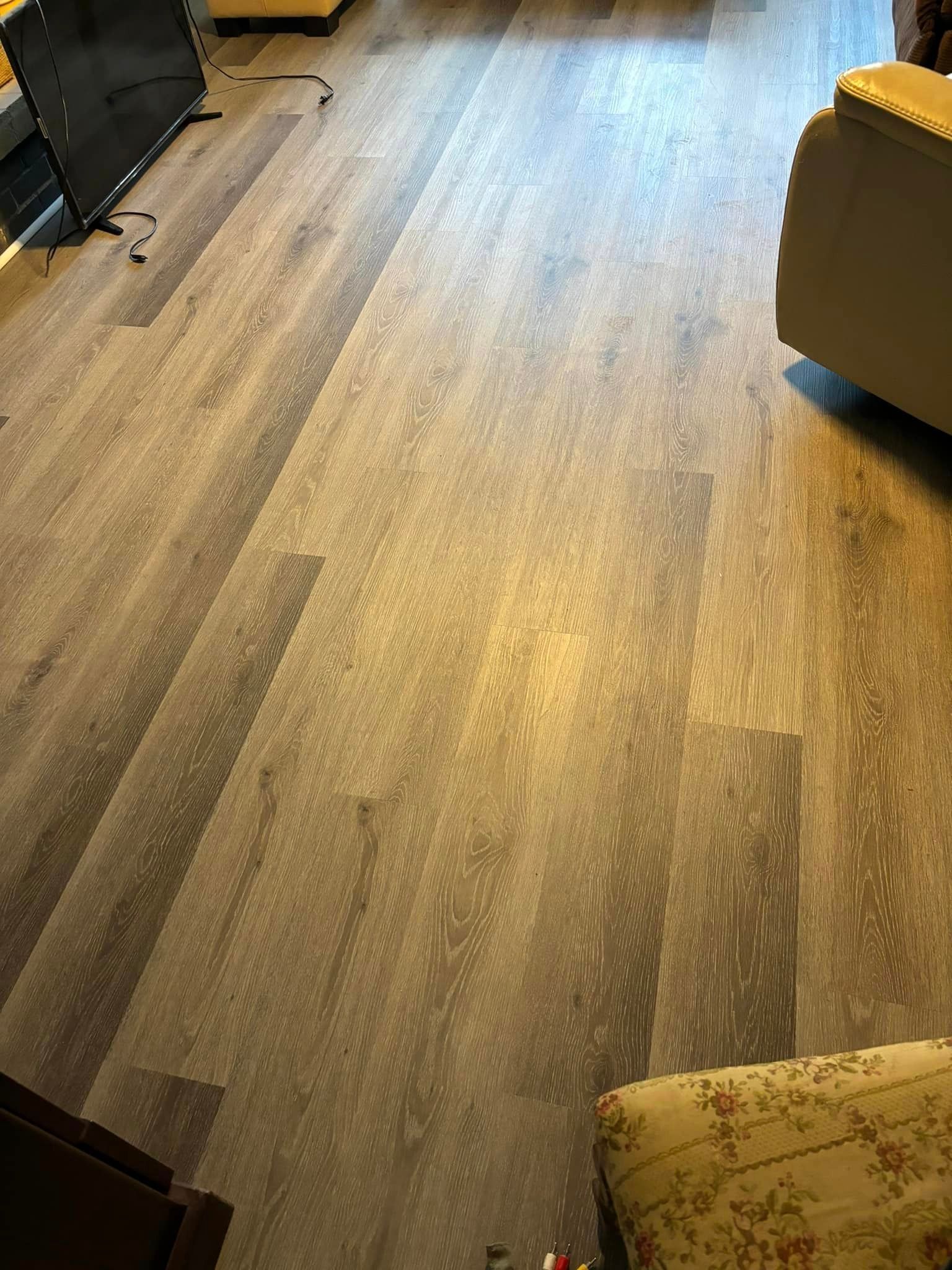 A living room with a wooden floor and a couch.