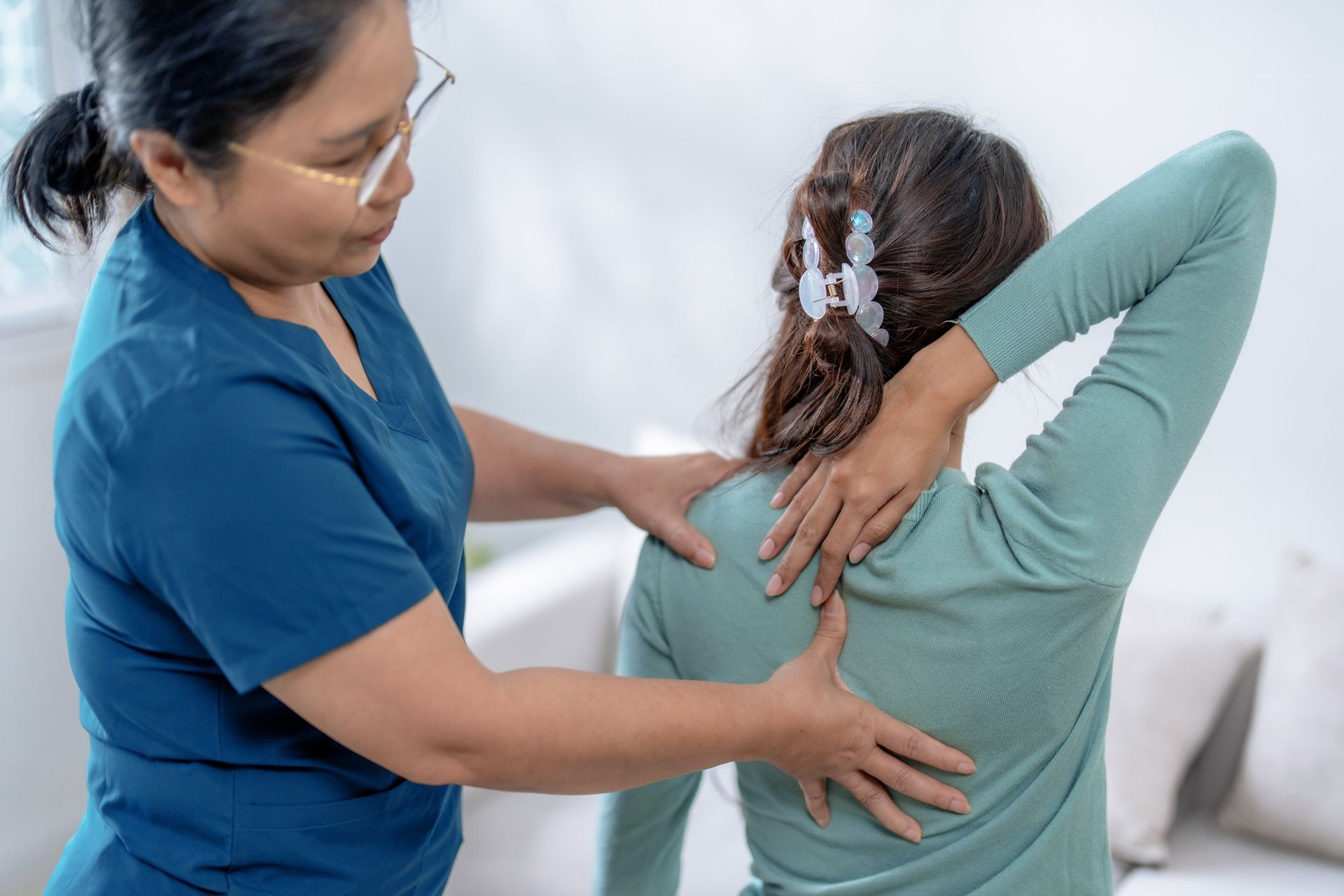 A nurse is examining a patient 's knee in a hospital room.
