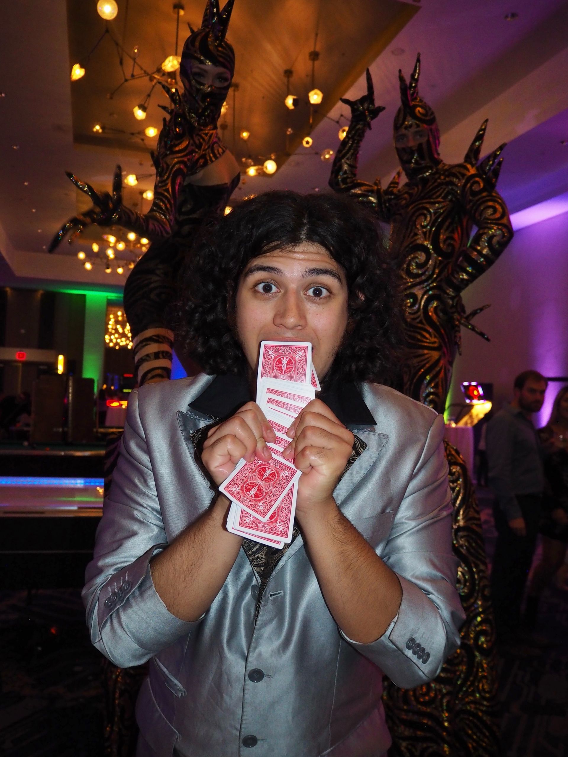 Las Vegas magician performs card tricks for guests during cocktail hour at a private corporate event.