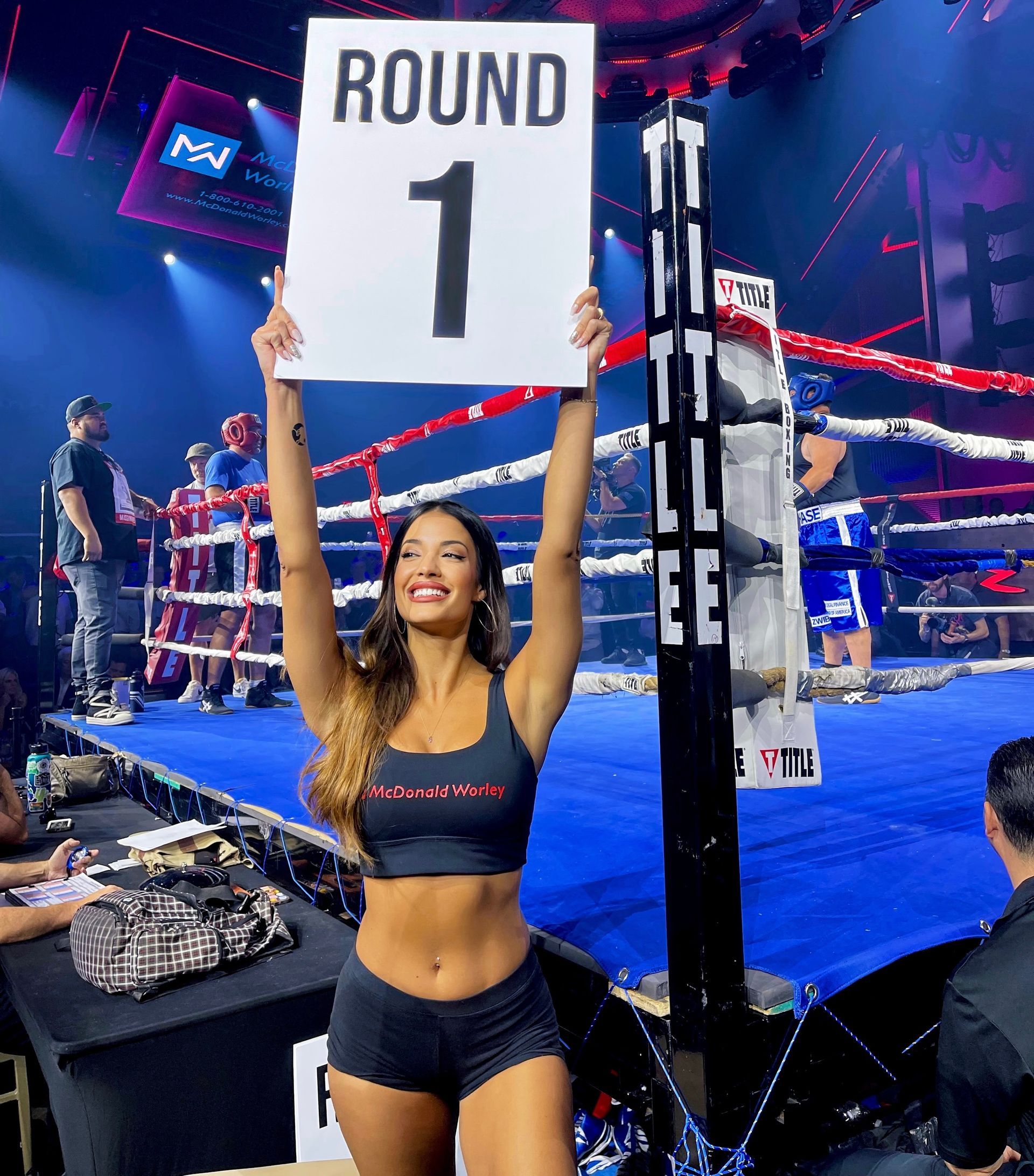 Beautiful ring girl holds round card and smiles at the cameras for boxing charity event at Zouk Nightclub, provided by Legend Entertainment Las Vegas.
